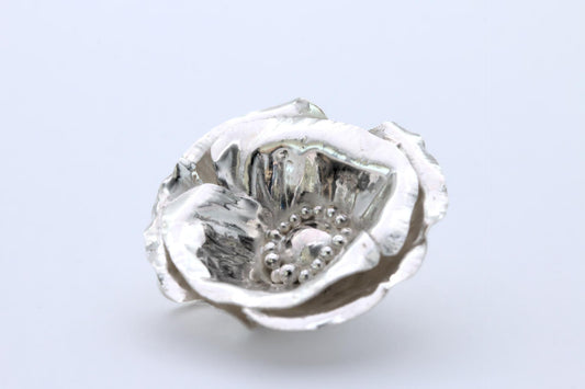 a delicate poppy flower pendant in silver